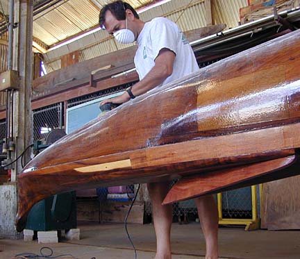 Craftsman sanding canoe hull