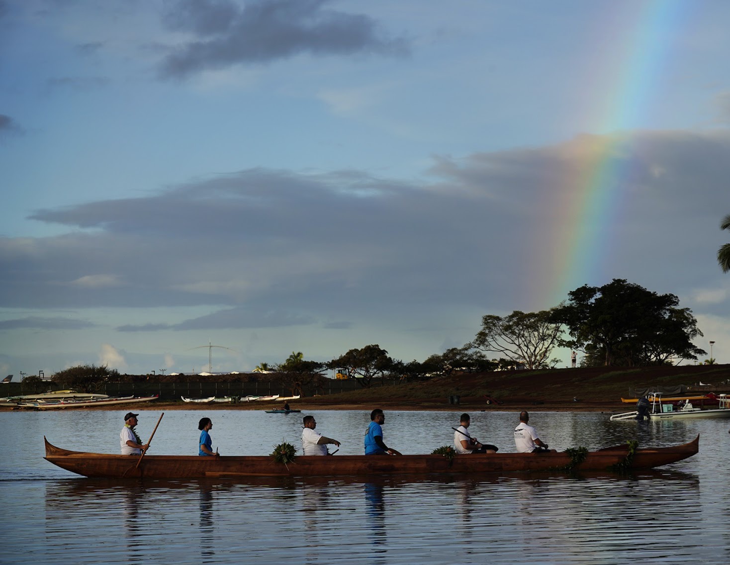 Canoe on calm water with rainbow